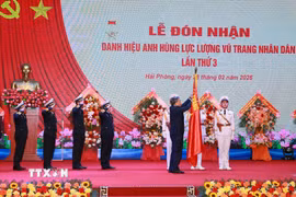 Tổng Bí thư Tô Lâm, Bí thư Quân ủy Trung gắn Huy hiệu Anh hùng Lực lượng Vũ trang nhân dân lên Quân kỳ Quyết thắng của Quân chủng Hải quân. (Ảnh: Trọng Đức/TTXVN)