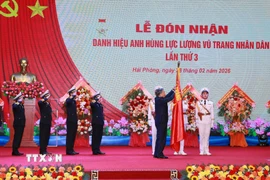 Tổng Bí thư Tô Lâm, Bí thư Quân ủy Trung gắn Huy hiệu Anh hùng Lực lượng Vũ trang nhân dân lên Quân kỳ Quyết thắng của Quân chủng Hải quân. (Ảnh: Trọng Đức/TTXVN)
