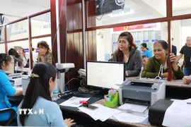 Người dân liên hệ bộ phận một cửa giải quyết các vấn đề liên quan hộ tịch ở phường Nha Trang, tỉnh Khánh Hòa trong ngày làm việc đầu tiên của chính quyền 2 cấp. (Ảnh: Phan Sáu/TTXVN)