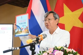 Đại sứ Việt Nam tại Cuba Lê Quang Long giới thiệu với bạn bè Cuba ấn phẩm đặc biệt “Việt Nam-Cuba: 65 năm tình anh em.” (Ảnh: Việt Hùng/TTXVN)