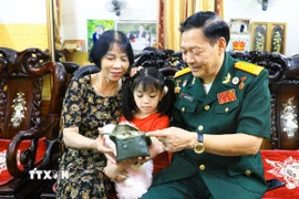 Cựu chiến binh Phạm Thanh Tịnh xem lại kỷ vật trong chiến trường xưa. (Ảnh: Phan Quân/TTXVN)