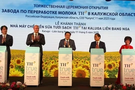 Lãnh đạo Việt Nam, Liên bang Nga, đại diện doanh nghiệp nhấn nút khởi động Nhà máy chế biến sữa tươi sạch TH. (Ảnh: Tâm Hằng/TTXVN)