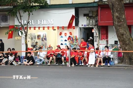 Khắp các tuyến phố trung tâm Hà Nội đã rực rỡ sắc đỏ cờ hoa, trang phục cờ đỏ sao vàng của người dân giữ chỗ, chờ đón đến giờ tổng hợp luyện lần thứ nhất. (Ảnh: Vũ Quang/TTXVN)