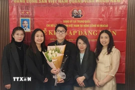 Nguyễn Thị Xuân Huệ (thứ hai, bên trái), nghiên cứu sinh chuyên ngành Ngôn ngữ học ứng dụng tiếng Anh tại Đại học Macau (Trung Quốc), Bí thư Chi bộ Lưu học sinh Việt Nam tại Hong Kong và Macau tại lễ kết nạp đảng viên mới. (Nguồn: TTXVN phát)