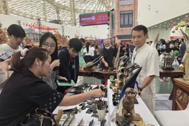 Nghệ nhân Nguyễn Văn Sử, chủ cơ sở mỹ nghệ sừng Mười Sử giới thiệu sản phẩm cho khách hàng. (Ảnh: PV/Vietnam+)