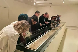 Khách tham quan chiêm ngưỡng cuộn sách dài 7 mét trong phòng trưng bày được kiểm soát khí hậu đặc biệt. (Nguồn: Times of Israel)