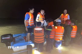 Các lực lượng chức năng giải cứu thành công nhiều người dân bị mắc kẹt giữa dòng nước lũ tại Quảng Trị. (Nguồn: TTXVN phát)