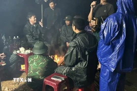 Các lực lượng chức năng đang bàn bạc phương án tìm kiếm em N.Đ.H. (Nguồn: TTXVN phát)