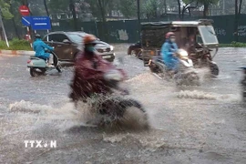 Chỉ sau vài phút mưa, tuyến phố Đào Tấn đã ngập úng diện rộng. (Ảnh: Văn Điệp/TTXVN)