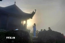 Phật tử "vượt sương, đi xuyên màn đêm" để đón bình minh trên chùa Đồng, nơi đỉnh thiêng Yên Tử, sáng sớm 5/10. (Ảnh: Thanh Vân/TTXVN)