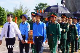 Lãnh đạo tỉnh Đồng Tháp thực hiện nghi thức đưa hài cốt liệt sỹ đến nơi an nghỉ. (Ảnh: Nhựt An/TTXVN)
