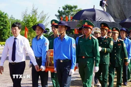 Lãnh đạo tỉnh Đồng Tháp thực hiện nghi thức đưa hài cốt liệt sỹ đến nơi an nghỉ. (Ảnh: Nhựt An/TTXVN)