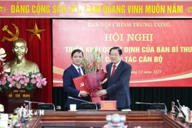 Ông Phan Đình Trạc, Ủy viên Bộ Chính trị, Bí thư Trung ương Đảng, Trưởng Ban Nội chính Trung ương trao Quyết định của Ban Bí thư cho ông Nguyễn Xuân Trường. (Ảnh: Phương Hoa/TTXVN)