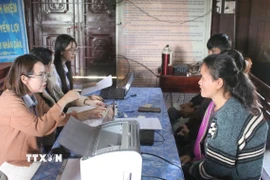 Cán bộ Trung tâm phục vụ hành chính công xã Ya Ly, tỉnh Quảng Ngãi hướng dẫn người dân nộp hồ sơ tại buổi tiếp nhận thủ tục hành chính lưu động. (Ảnh: Dư Toán/TTXVN)
