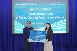 Ông Đặng Thanh Hải, Phó Tổng Giám đốc Nhà Xuất bản Giáo dục Việt Nam, trao biển tặng sách giáo khoa cho bà Võ Thị Minh Duyên, Phó Giám đốc Sở Giáo dục và Đào tạo tỉnh Đắk Lắk. (Nguồn: Vietnam+)