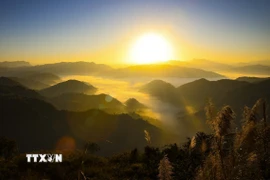 Ánh nắng mặt trời xuyên qua những áng mây bồng bềnh giữa núi đồi. (Ảnh: Xuân Tư/TTXVN)