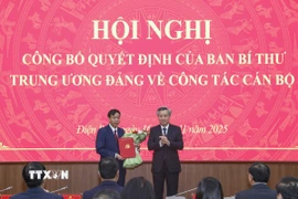 Phó Trưởng Ban Tổ chức Trung ương Nguyễn Quang Dương trao Quyết định và tặng hoa chúc mừng ông Lê Văn Lương. (Ảnh: Xuân Tư/TTXVN)