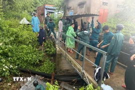 Cán bộ, chiến sỹ Đồn biên phòng cửa khẩu cảng Nha Trang phối hợp cùng các lực lượng địa phương tổ chức khơi thông các kênh, rãnh thoát nước không để tắc nghẽn. (Nguồn: TTXVN phát)