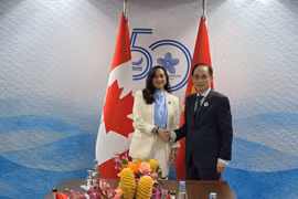 Bộ trưởng Ngoại giao Lê Hoài Trung và Bộ trưởng Ngoại giao Canada Anita Ananda chụp ảnh chung. (Ảnh: Việt Dũng/TTXVN)