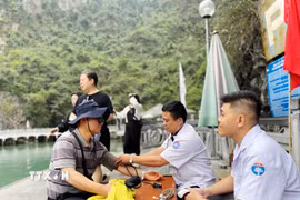 Nhân viên y tế tư vấn, kiểm tra sức khỏe cho du khách nước ngoài tại điểm trực y tế thường trực trên vịnh Hạ Long. (Ảnh: TTXVN phát)