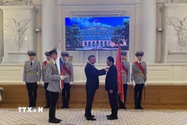 Thống đốc A.Beglov gắn huy hiệu danh dự cho ông Nguyễn Quốc Hùng. (Ảnh: Tâm Hằng/TTXVN)