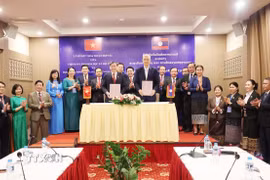 Giáo sư, Tiến sỹ Lê Văn Lợi, Chủ tịch Viện Hàn lâm Khoa học xã hội Việt Nam và Tiến sỹ Anouphap Tounalom, Giám đốc Học viện Chính trị và Hành chính quốc gia Lào trao đổi Biên bản hợp tác khoa học giai đoạn 2026-2030. (Ảnh: Xuân Tú/TTXVN)