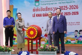 Hiệu trưởng Trường song ngữ Lào-Việt Nam Nguyễn Du Nguyễn Thị Thanh Hương đánh trống khai giảng năm học mới 2025-2026. (Ảnh: Xuân Tú/TTXVN)