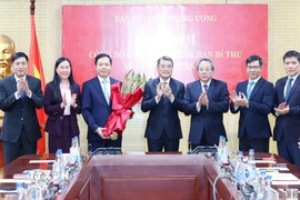 Các đồng chí lãnh đạo Ban Tổ chức Trung ương tặng hoa chúc mừng ông Trịnh Mạnh Linh. (Ảnh: Phương Hoa/TTXVN)