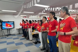 Tập thể nhân viên Công ty VTI hát quốc ca chào mừng lễ kỷ niệm 50 năm thống nhất đất nước. (Ảnh: Nguyễn Tuyến/TTXVN)