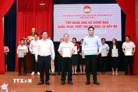 Đại diện Ủy ban Mặt trận Tổ quốc Việt Nam Thành phố Hồ Chí Minh và Ban Vận động Cứu trợ Thành phố Hồ Chí Minh tiếp nhận sự ủng hộ, trao thư cảm ơn các doanh nghiệp ủng hộ đồng bào khắc phục hậu quả thiên tai. (Ảnh: Xuân Khu/TTXVN)
