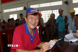 Người dân phường Ngã Năm phấn khởi nhận quà Quốc khánh 2/9 từ Chính phủ. (Ảnh: Tuấn Phi/TTXVN)