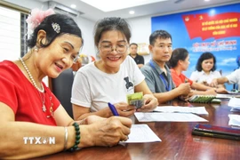 Người dân đến đăng ký nhận quà tại điểm chi trả phường Bồ Đề (Hà Nội). (Ảnh: Minh Quyết/TTXVN)