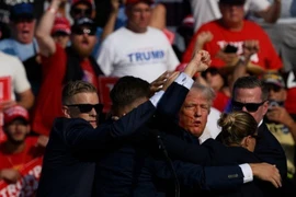 Ông Donald Trump được mật vụ Mỹ hộ tống rời khỏi bục diễn thuyết trong cuộc vận động tranh cử ở thành phố Butler, bang Pennsylvania sau khi xảy ra vụ nổ súng, ngày 13/7/2024. (Ảnh: Getty Images/TTXVN)