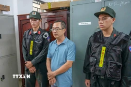 Bị can Nguyễn Quốc Trưởng, cựu Giám đốc OceanBank chi nhánh Cần Thơ nghe tống đạt các quyết định tố tụng. (Nguồn: TTXVN phát)