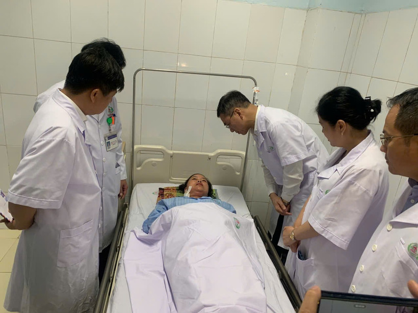 Tiến sỹ Hà Anh Đức - Cục trưởng Cục Quản lý Khám chữa bệnh thăm hỏi, động viên nữ điều dưỡng đang bị thương. (Ảnh: PV/Vietnam+) 