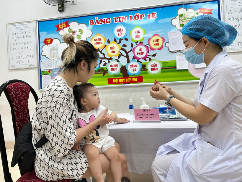 Phụ huynh cho trẻ đến trạm y tế để bổ sung Vitamin A. (Ảnh: PV/Vietnam+)