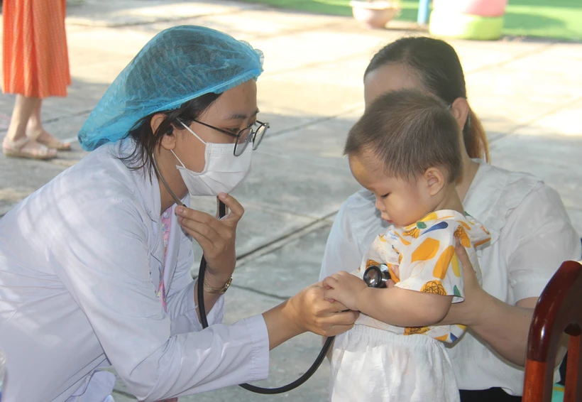 Thăm khám cho trẻ trước khi tiêm vaccine phòng sởi. (Ảnh: Ánh Tuyết/TTXVN)