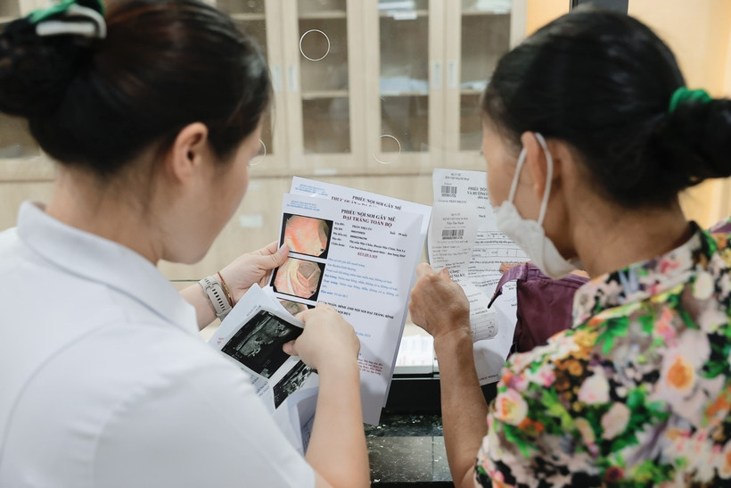 Nhân viên y tế tư vấn cho người bệnh. (Ảnh: Minh Quyết/TTXVN)