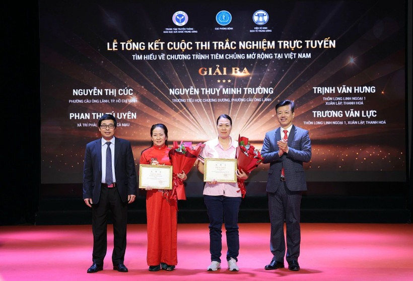 Ban Tổ chức trao chứng nhận và hoa cho các tác giả đoạt giải. (Ảnh: PV/Vietnam+)