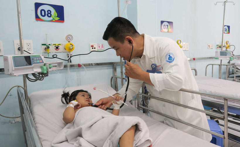 Bác sỹ Bệnh viện Nhi đồng 1 Thành phố Hồ Chí Minh, khám cho bệnh nhi mắc tay chân miệng. (Ảnh: Đinh Hằng/TTXVN)