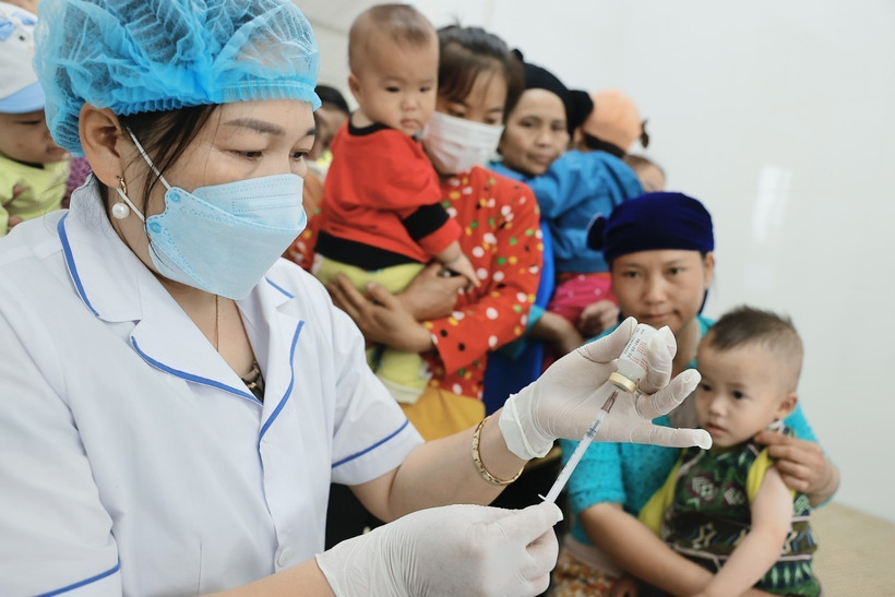 Người dân đưa trẻ đến tiêm chủng. (Ảnh: Minh Quyết/TTXVN)