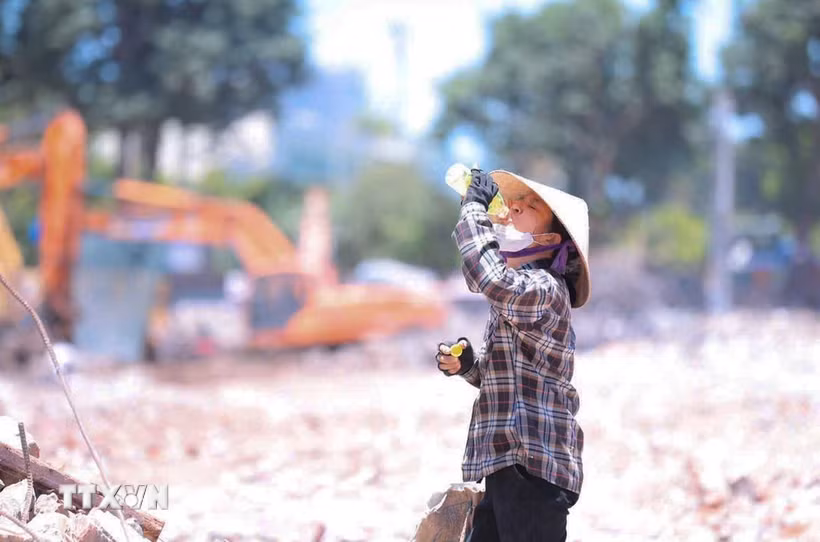 Nhiệt độ ngoài trời tăng cao, người lao động phải chật vật mưu sinh. (Ảnh: Hoàng Hiếu/TTXVN)