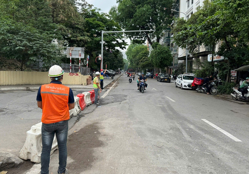 Công nhân nhà thầu thi công Dự án đường sắt đô thị đoạn Nhổn-Ga Hà Nội tổ chức phân luồng giao thông. (Ảnh: PV/Vietnam+)