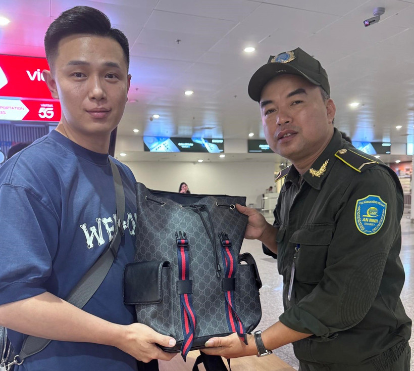 Nhân viên Sân bay Nội Bài hỗ trợ khách Trung Quốc tìm lại tài sản bỏ quên trên xe taxi. (Ảnh: PV/Vietnam+)