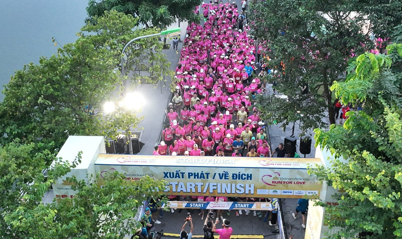 Khoảnh khắc tập thể bứt tốc, khi vận động viên khiếm thị và bạn dẫn cùng hòa nhịp, biến đường chạy thành bản giao hưởng yêu thương của mùa thu Hà Nội. (Ảnh: VNA).