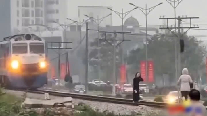 Ảnh chụp từ clip ghi nhận hai người phụ nữ 'sống ảo' ngay trước mũi tàu khách đang chạy. 