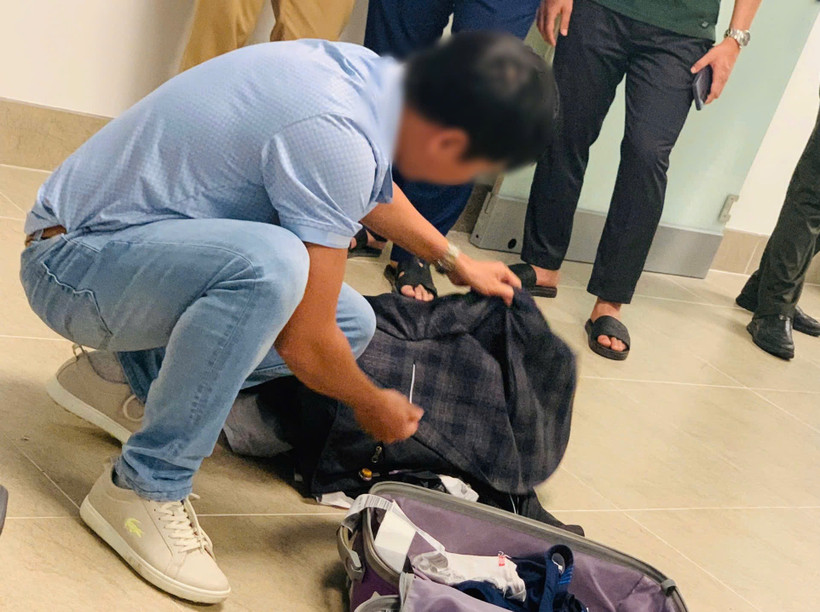 Kiểm tra hành lý xách tay của hành khách nói đùa có bom ngay khi vừa hạ cánh tại Sân bay Nội Bài. (Ảnh: PV/Vietnam+)