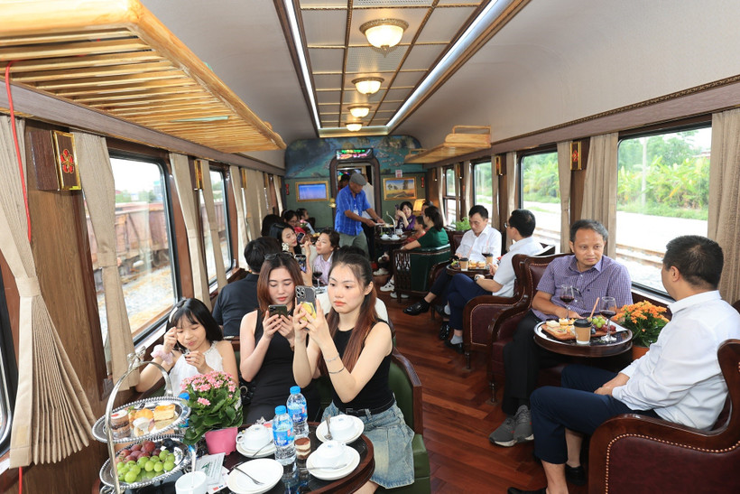 Những hành khách đầu tiên tham gia trải nghiệm toa hạng sang trên đoàn tàu Hoa Phượng đỏ. (Ảnh: Việt Hùng/Vietnam+)