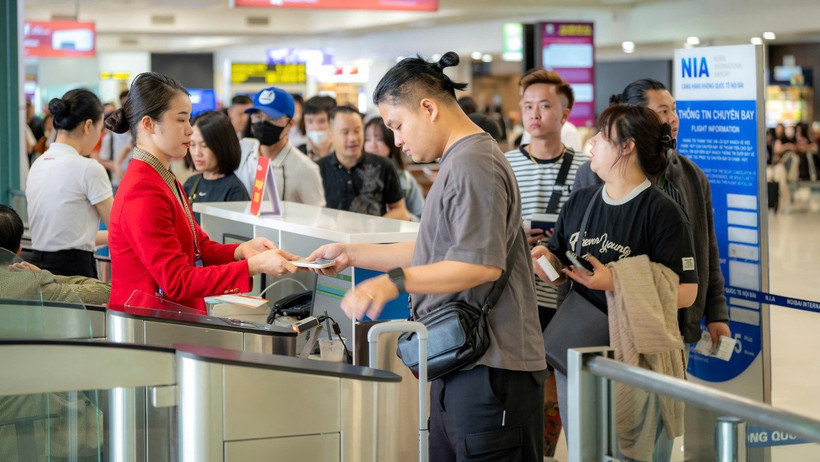 Hành khách xếp hàng làm thủ tục tại cửa ra tàu bay tại Cảng hàng không Quốc tế Nội Bài. (Ảnh: PV/Vietnam+)