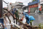 Công an xã Quỹ Nhất giúp người dân khắc phục hậu quả. (Ảnh: Công Luật/TTXVN)